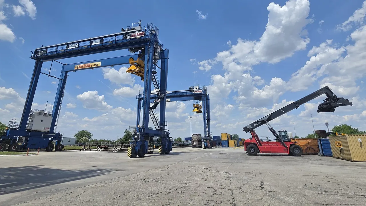 Two blue gantry cranes and a red reachstacker on the handling area of the Arad terminal