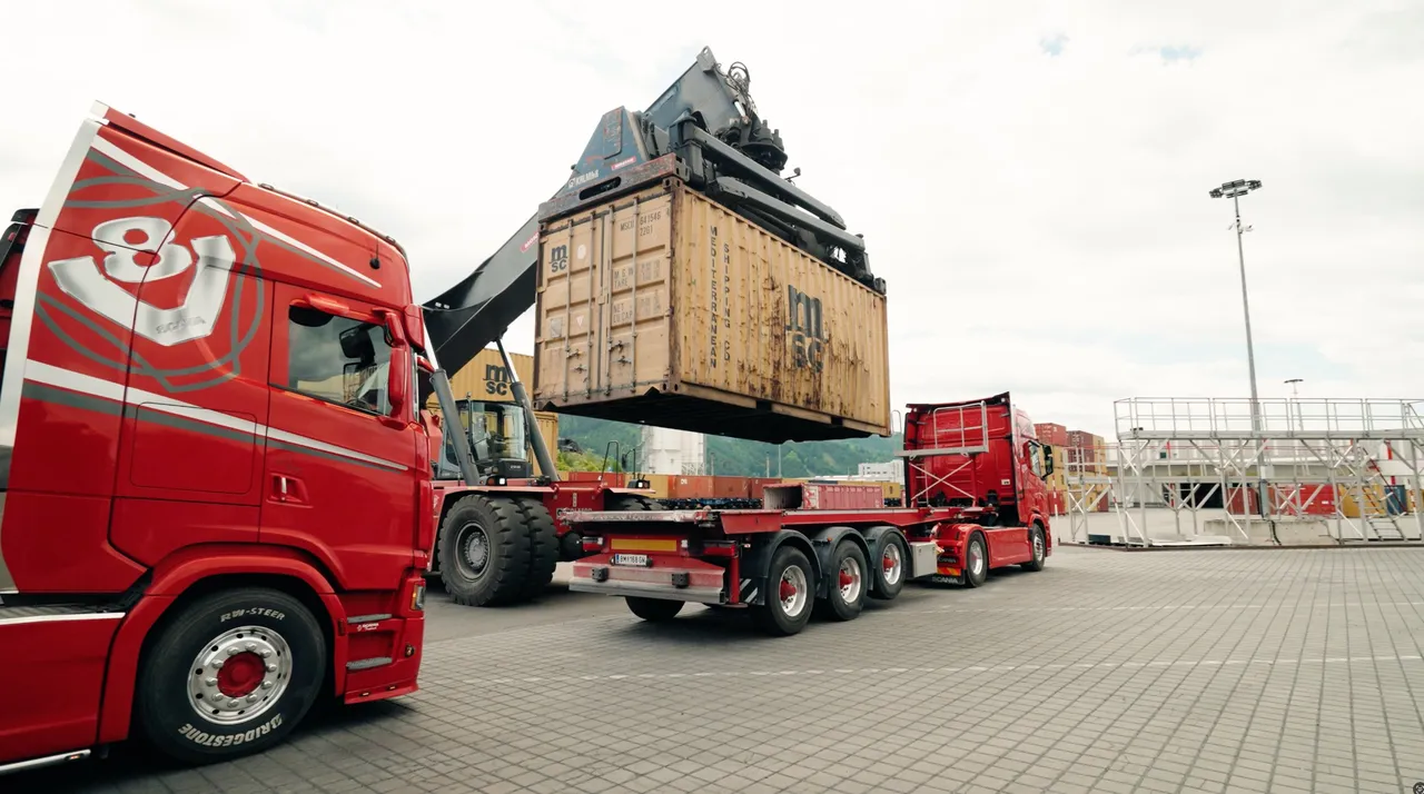 Reachstacker setzt einen Wechselbehaelter auf einen Lkw-Anhaenger am Terminal Kapfenberg
